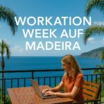 Frau mit Laptop auf Balkon mit Meerblick
